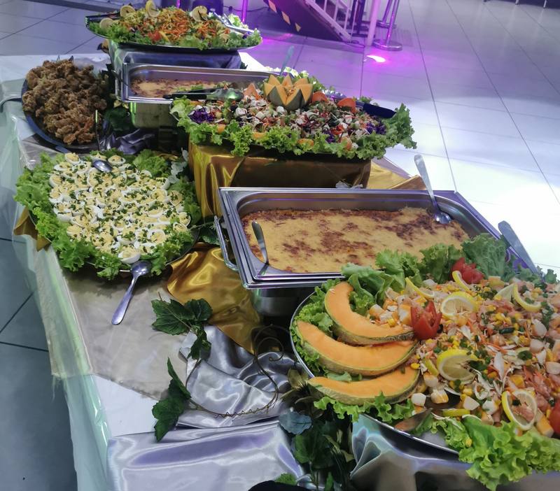 Buffet en salle : salades composées, œufs mimosa, gratins et melon, sur nappes satinées or et argent